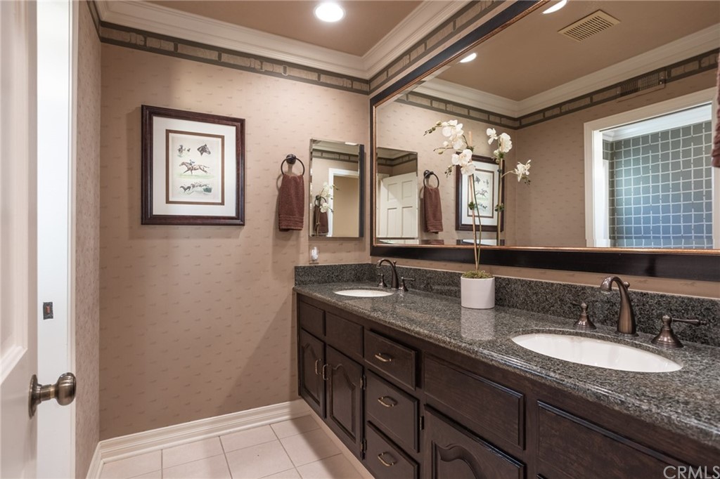 19051 Mesa Drive Villa Park, CA 92861 - Photo 8 of 28 a bathroom with a granite countertop sink a mirror a vanity and shower
