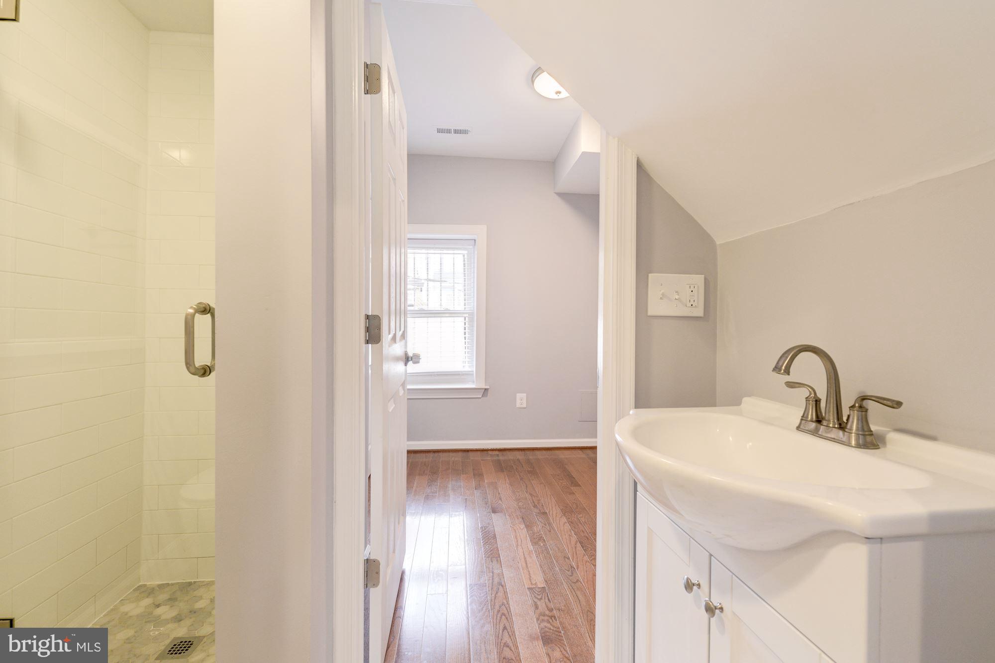 1914 10th Street Northwest Washington, DC 20001 - Photo 16 of 27 a bathroom with a sink a mirror and a shower