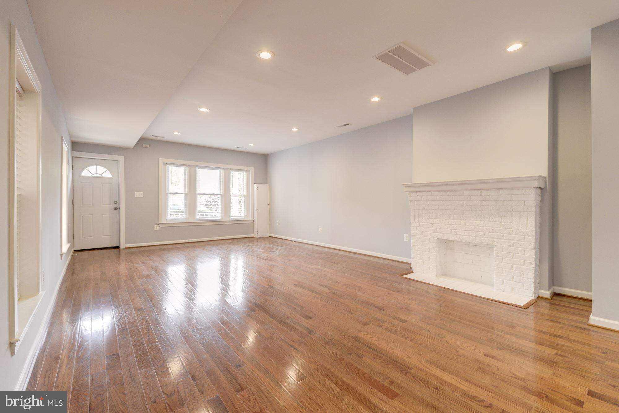 1914 10th Street Northwest Washington, DC 20001 - Photo 4 of 27 a view of an empty room with wooden floor and a window