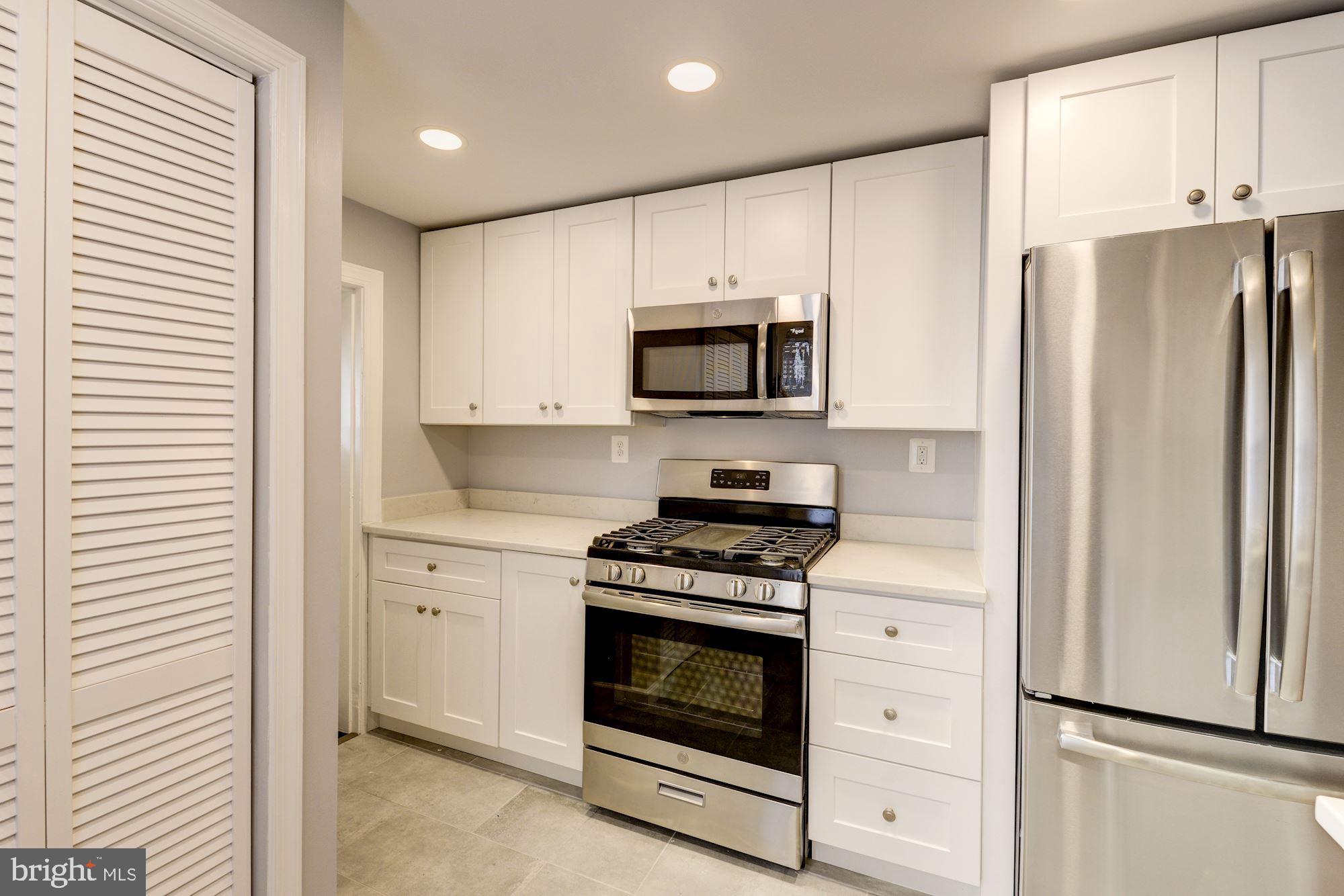 1914 10th Street Northwest Washington, DC 20001 - Photo 8 of 27 a kitchen with stainless steel appliances white cabinets and a refrigerator