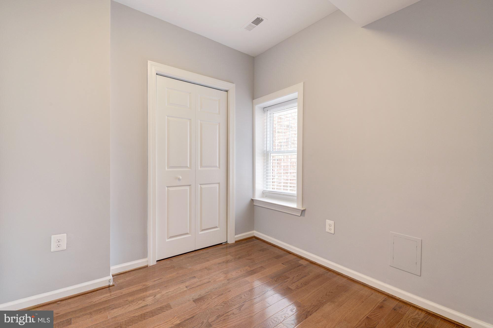 1914 10th Street Northwest Washington, DC 20001 - Photo 10 of 27 an empty room with wooden floor and windows