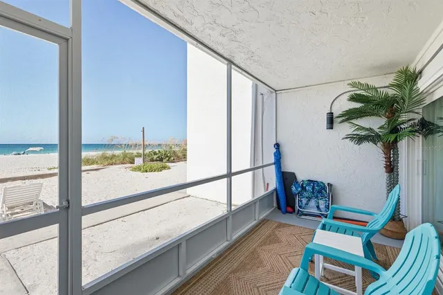 an aerial view of ocean and residential houses with outdoor space