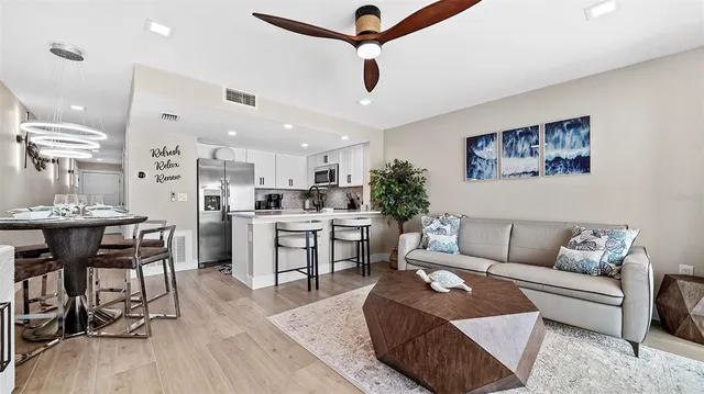 a living room with furniture potted plant and a large window