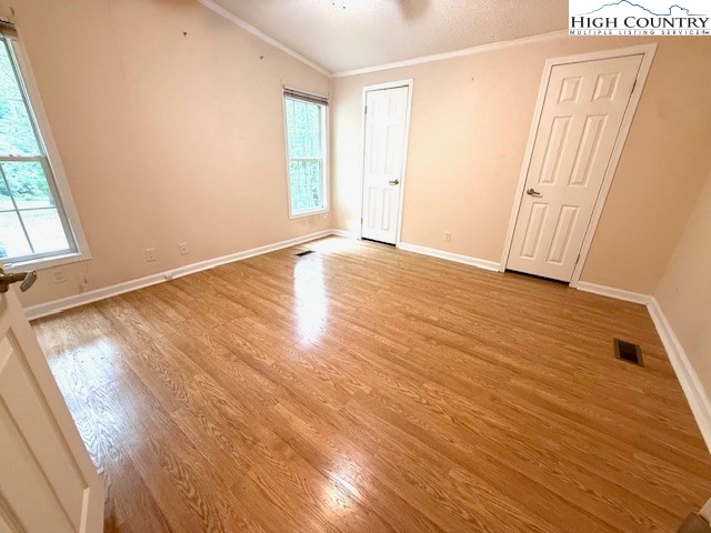 1269 Howell Road Lansing, NC 28643 - Photo 10 of 34 an empty room with wooden floor and windows