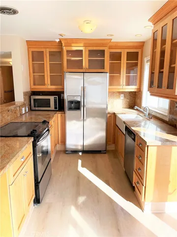 a kitchen with stainless steel appliances granite countertop a stove a sink and a microwave