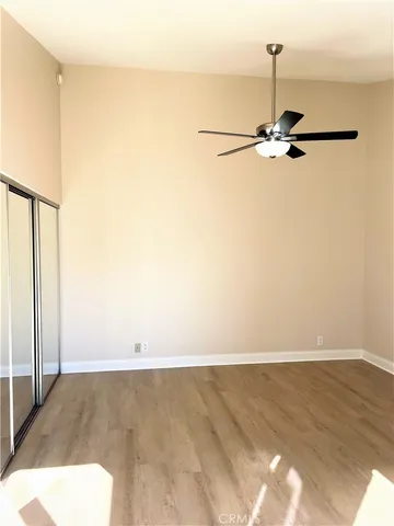 a view of a room with wooden floor and ceiling fan