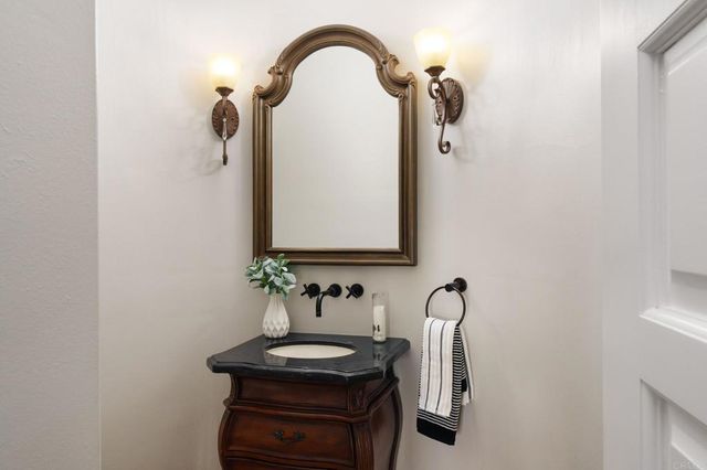 a bathroom with a granite countertop sink and a mirror