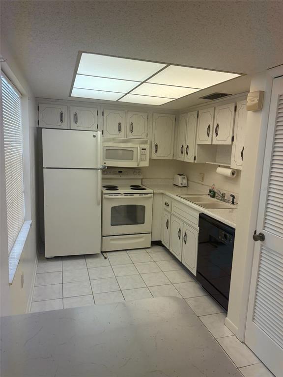 861 Maple Court, Unit 104 Dunedin, FL 34698 - Photo 13 of 14 a kitchen with stainless steel appliances granite countertop a stove a sink and a refrigerator