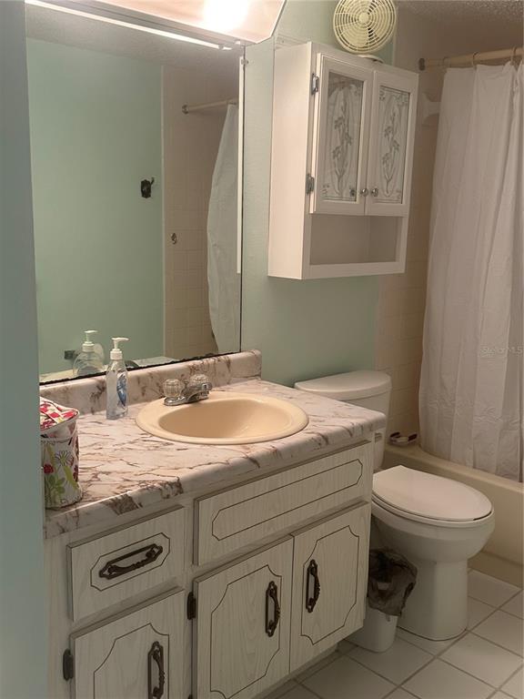 861 Maple Court, Unit 104 Dunedin, FL 34698 - Photo 5 of 14 a bathroom with a granite countertop toilet sink and mirror