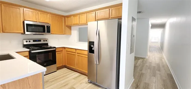 a kitchen with stainless steel appliances a refrigerator stove and microwave