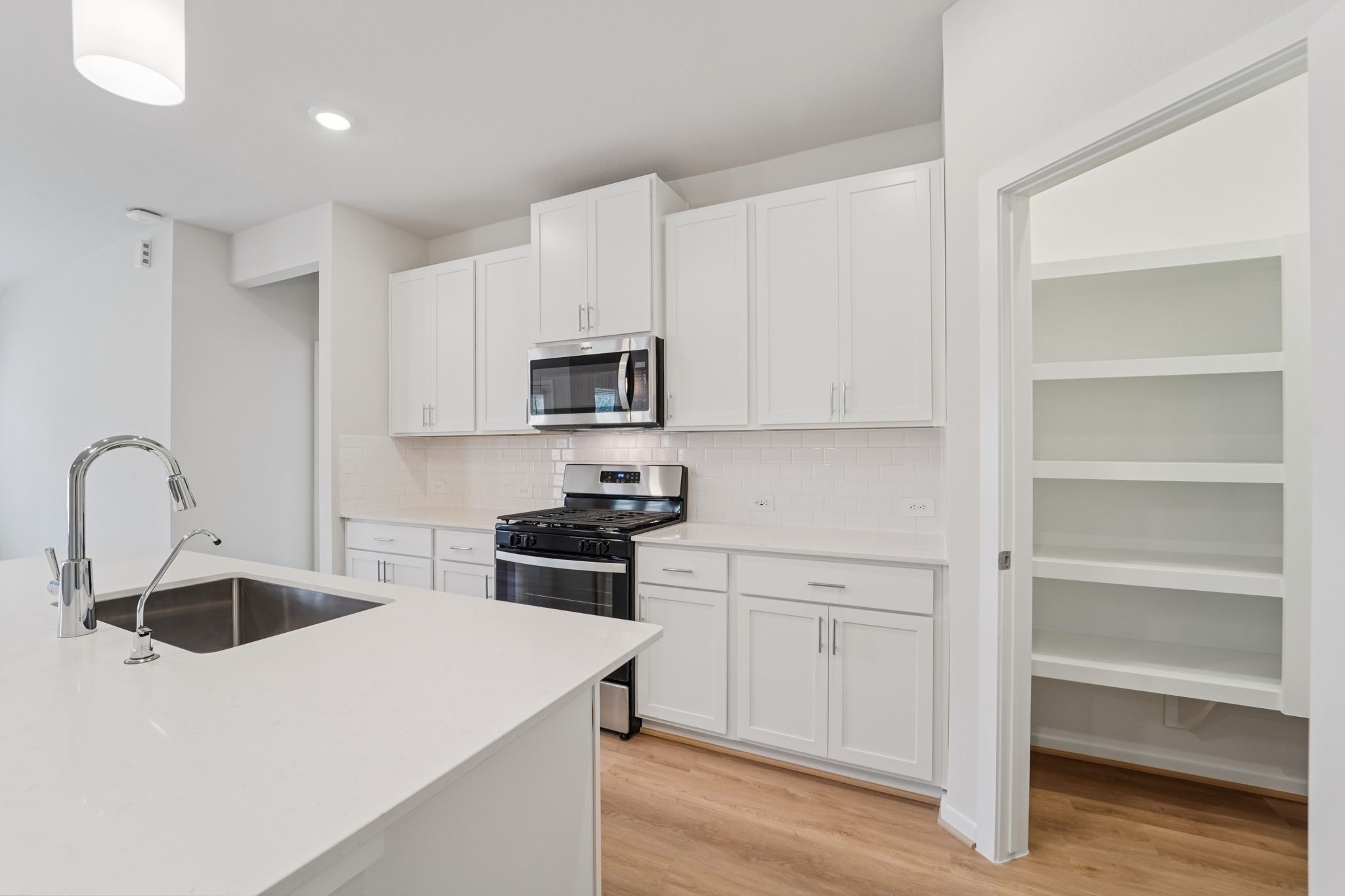 16253 Parish Pointe Court Conroe, TX 77302 - Photo 6 of 15 a kitchen with white cabinets appliances and sink