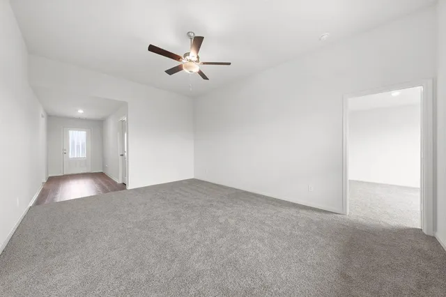 a view of a livingroom with a ceiling fan and window