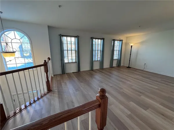 a view of a room with wooden floor and windows