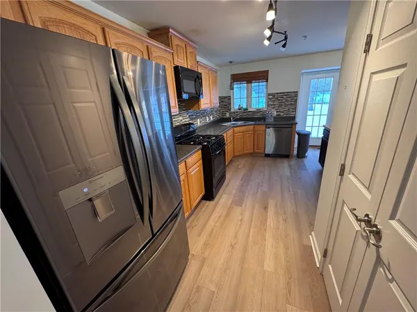 a kitchen with granite countertop stainless steel appliances a refrigerator a sink a stove a microwave and cabinets