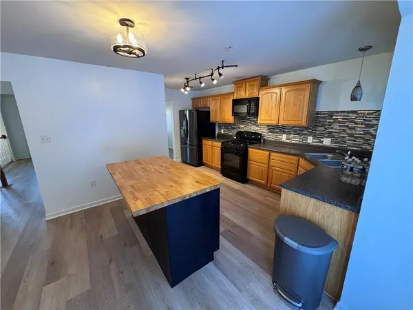 a kitchen with stainless steel appliances granite countertop a sink stove and wooden floor