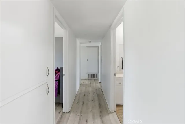a view of a hallway with wooden floor and closet