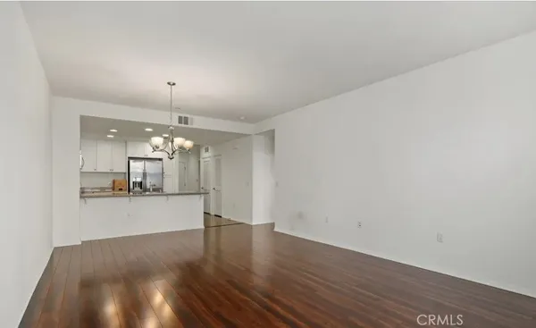 a big room with wooden floor and chandelier