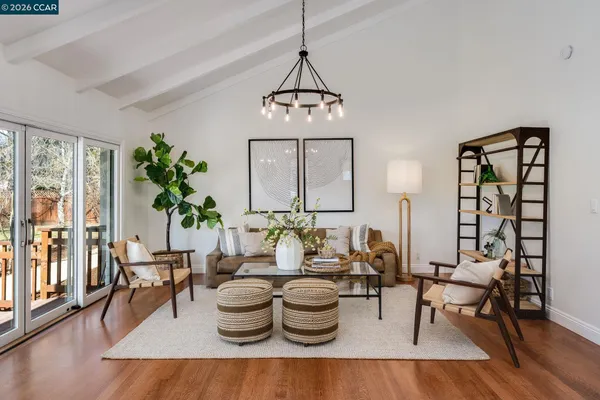 a view of a dining room with furniture a chandelier and wooden floor