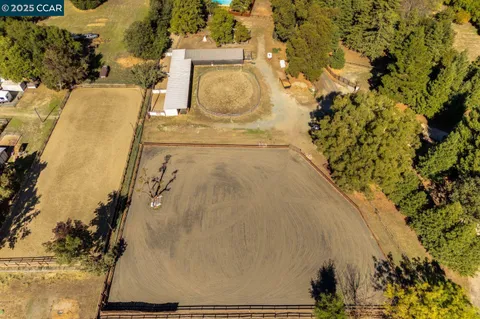 a kitchen with stainless steel appliances granite countertop a stove a refrigerator a microwave a dining table and chairs with wooden floor