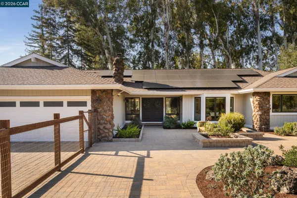 a view of a house with backyard sitting area and garden