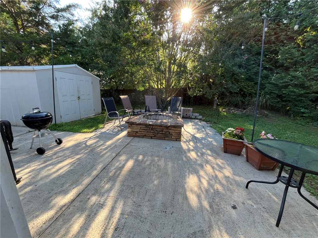 116 Arbors Court Central, SC 29630 - Photo 27 of 27 A private backyard retreat with a stone fire pit and mature landscaping for outdoor enjoyment.