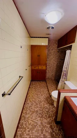 a bathroom with a sink a toilet a mirror and shower