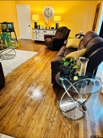 a living room with furniture and a wooden floor