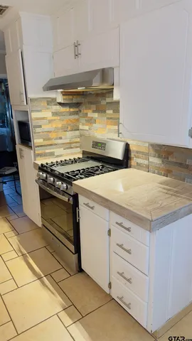 a kitchen with granite countertop a stove and a sink