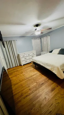 a bedroom with a bed and wooden floor