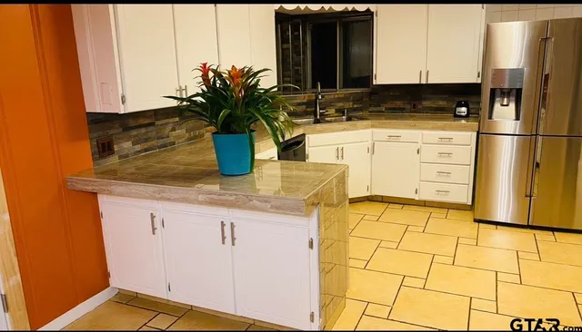 a kitchen with stainless steel appliances granite countertop a sink a stove and a refrigerator