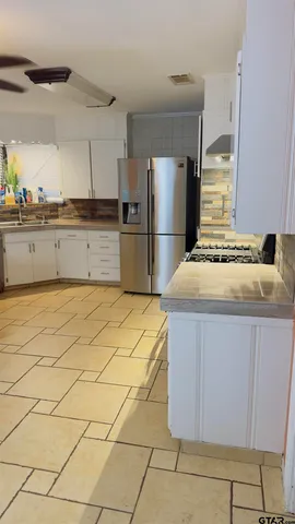 a kitchen with stainless steel appliances a sink and a refrigerator