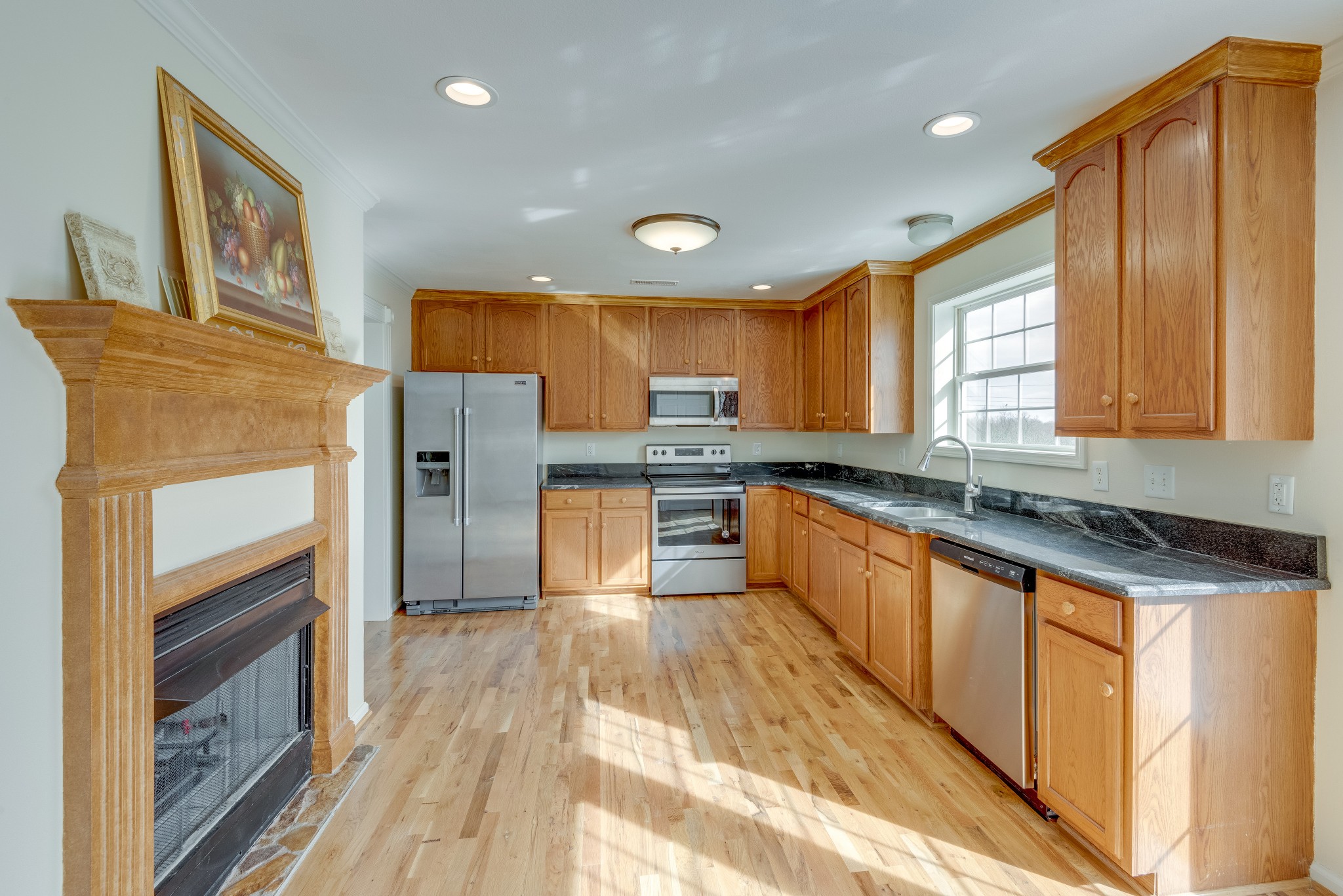 7349 Coldwater Road Fairview, TN 37062 - Photo 6 of 24 a large kitchen with stainless steel appliances granite countertop a refrigerator a sink dishwasher a stove and white countertops with wooden floor