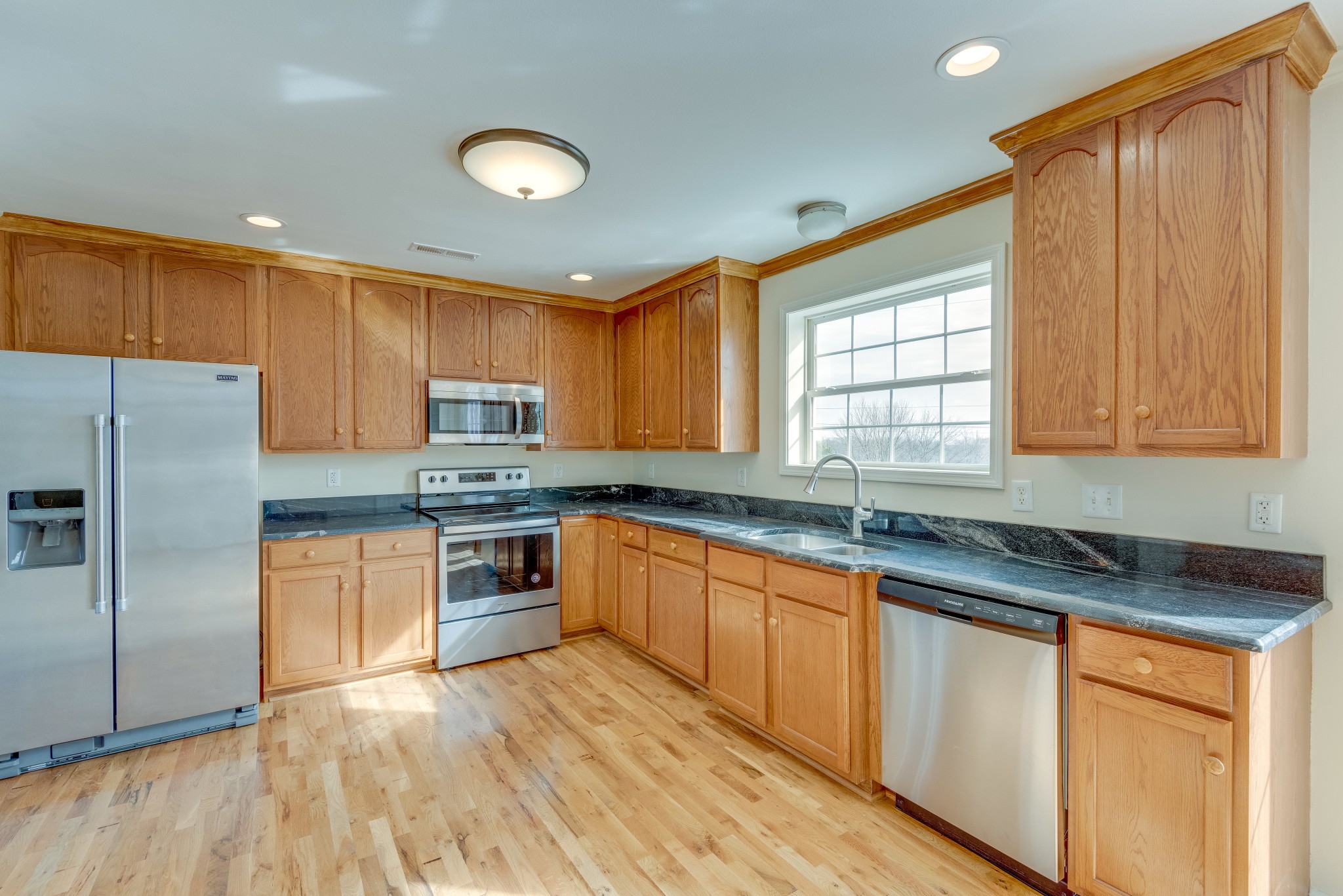 7349 Coldwater Road Fairview, TN 37062 - Photo 7 of 24 a kitchen with granite countertop a refrigerator sink and cabinets