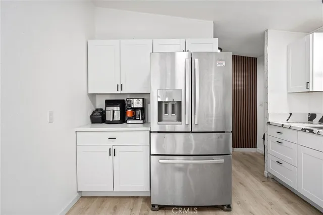 a kitchen with granite countertop white cabinets and white appliances