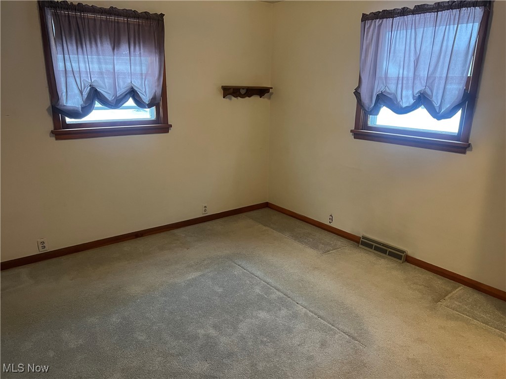7296 Poore Road Conneaut, OH 44030 - Photo 10 of 27 Empty room with healthy amount of natural light and light colored carpet