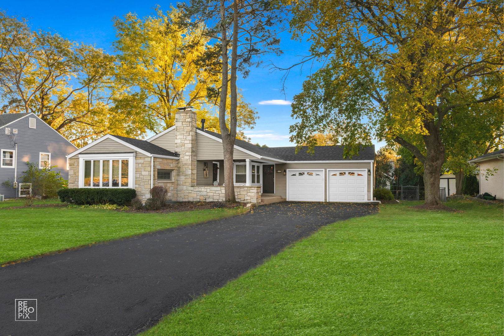 a front view of a house with a yard and trees