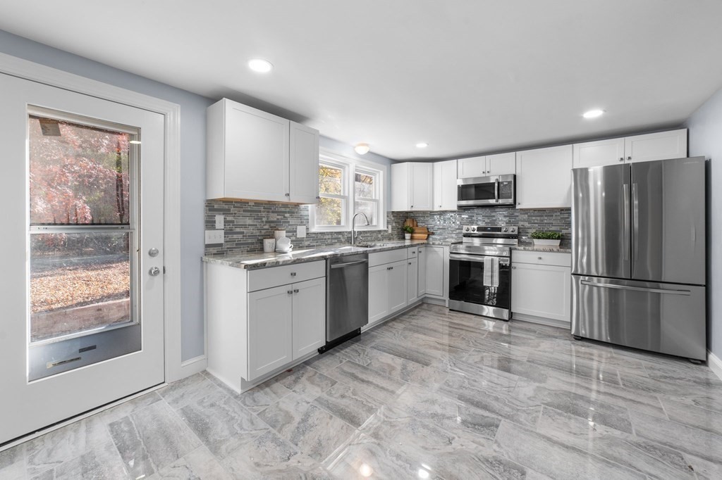 22 Leonard Road Sharon, MA 02067 - Photo 13 of 41 a kitchen with a refrigerator a stove top oven and kitchen island