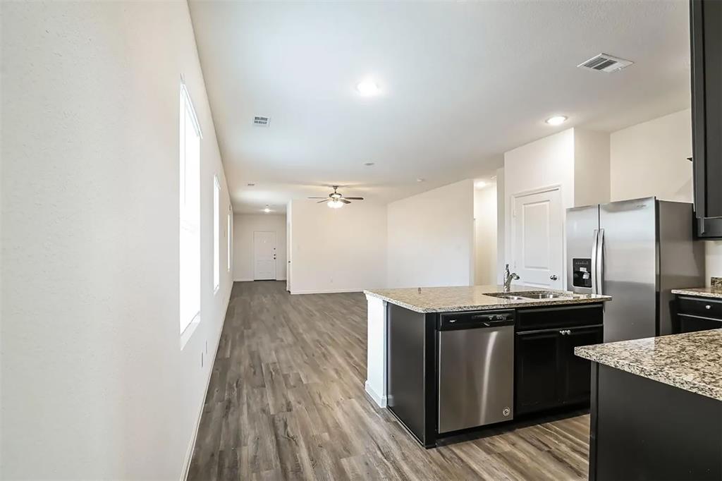 6214 Old Bridge Way Forney, TX 75126 - Photo 14 of 15 a kitchen with a sink a refrigerator and wooden floor