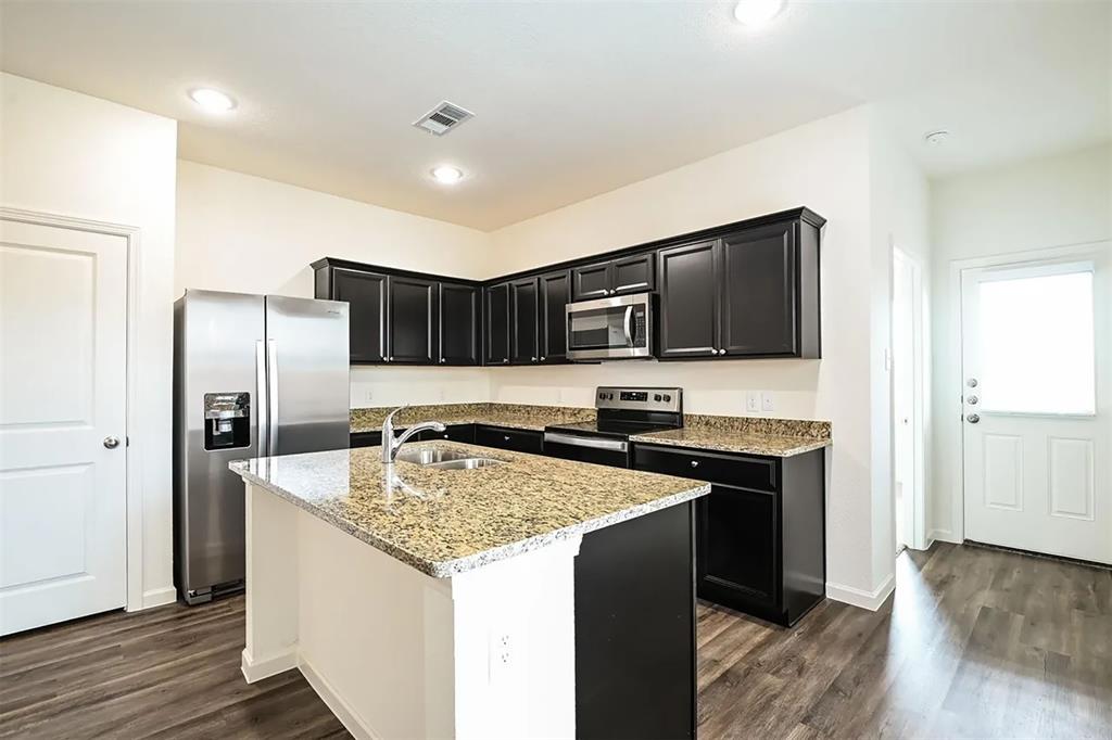 6214 Old Bridge Way Forney, TX 75126 - Photo 3 of 15 a kitchen with stainless steel appliances granite countertop a sink stove and refrigerator