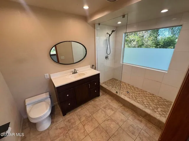 a bathroom with a toilet a sink and a mirror