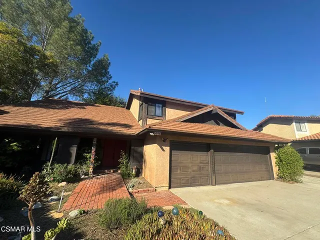 a front view of a house with a yard outdoor seating and garage
