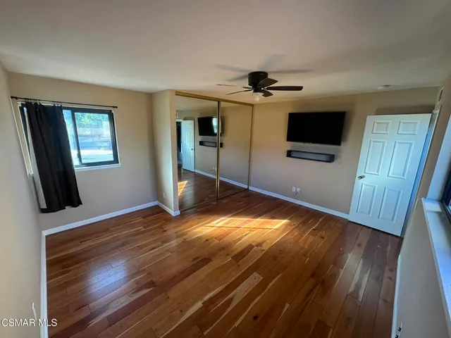 a view of a livingroom with wooden floor and a flat screen tv