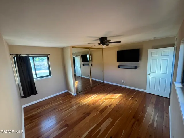 a view of a livingroom with wooden floor and a flat screen tv