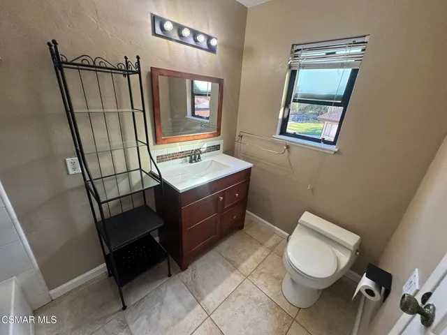 a bathroom with a toilet a sink a mirror and a bathtub