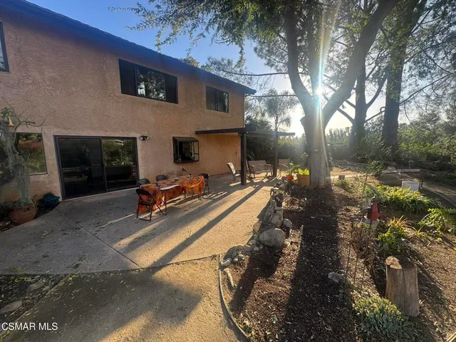 a view of a chair and table in backyard of the house