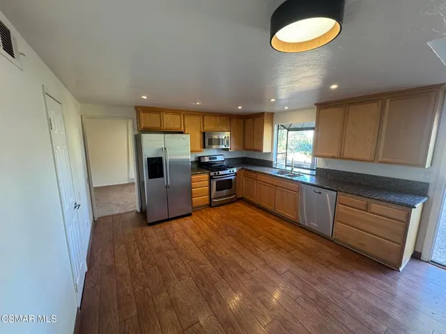 a kitchen with stainless steel appliances a stove a refrigerator and a sink