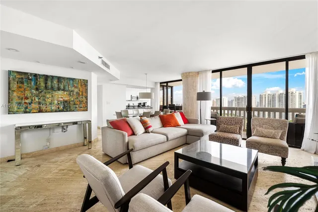 a living room with furniture and a flat screen tv next to a large window