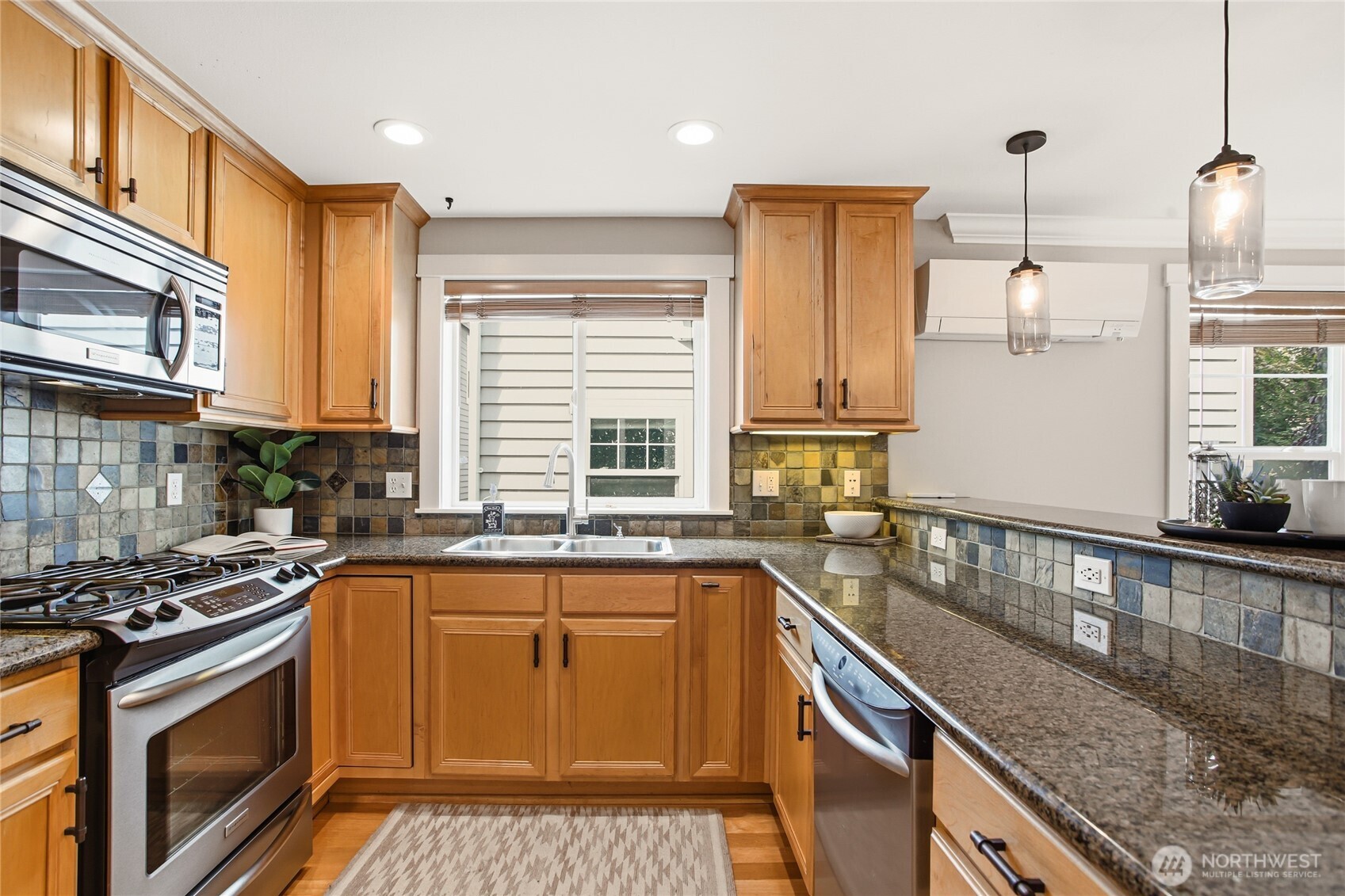 2635 Northwest 57th Street, Unit B Seattle, WA 98107 - Photo 11 of 28 a kitchen with stainless steel appliances granite countertop a sink a stove and a wooden cabinets