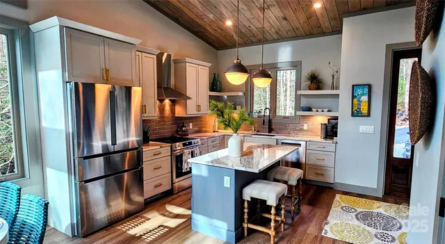 a kitchen with stainless steel appliances granite countertop a refrigerator and a stove top oven