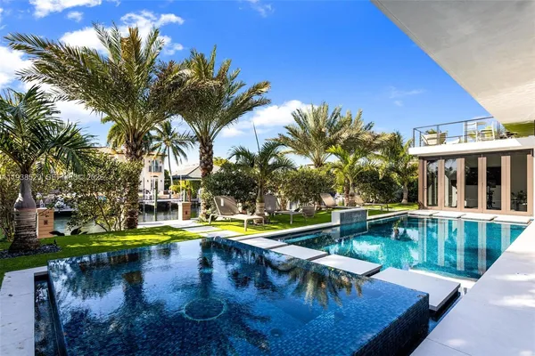 a bedroom with a large bed and a flat tv screen on dresser